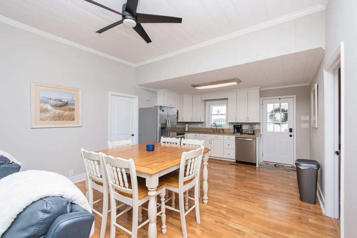 A cozy dining area featuring a wooden dining table set for a meal, modern kitchen appliances in the background, and warm, inviting artwork. The scene evokes a sense of togetherness and celebration, emphasizing communal meals and shared experiences.